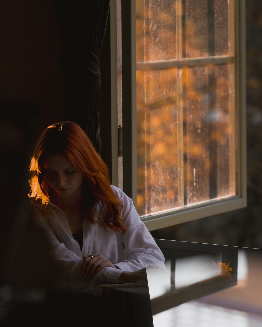 Persona contemplativa junto a una ventana con luz cálida